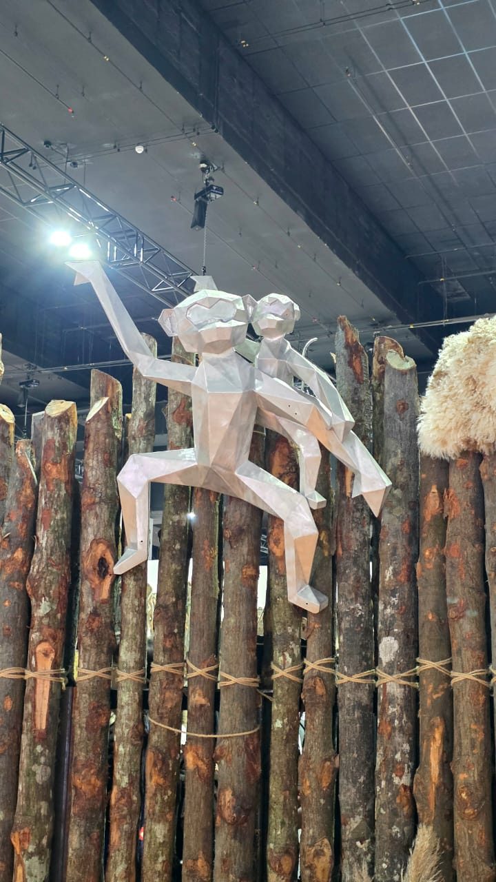 Suspended sculptural figures above the booth timber wall