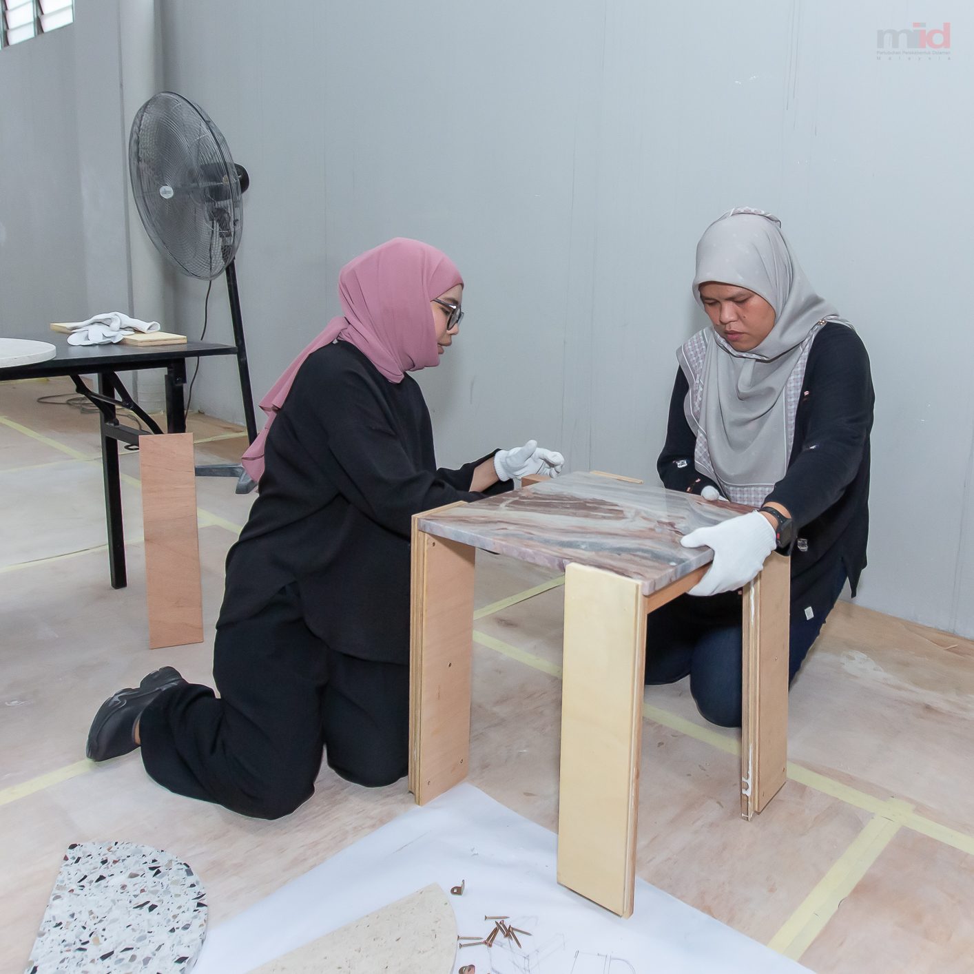 Participants assembling a stone topped side table